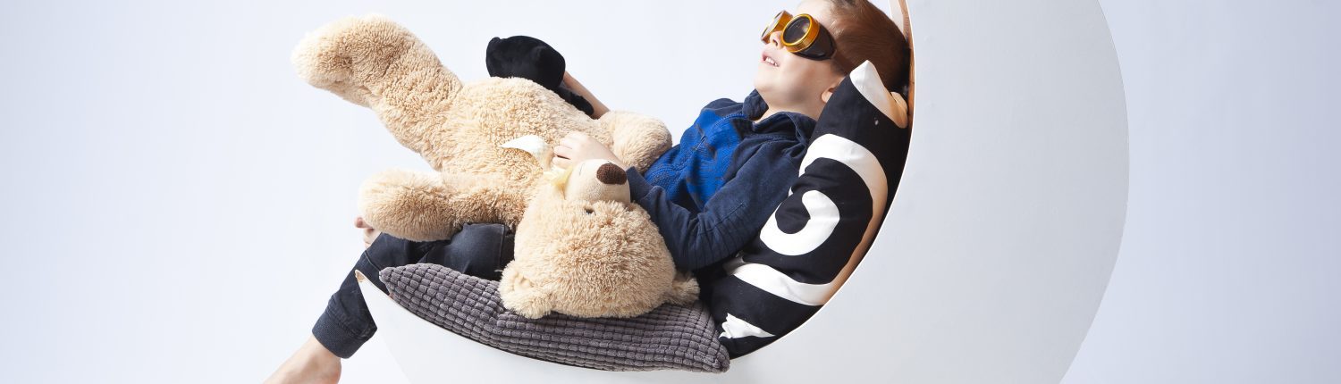 Cool dreng med solbriller slapper af i hængestol